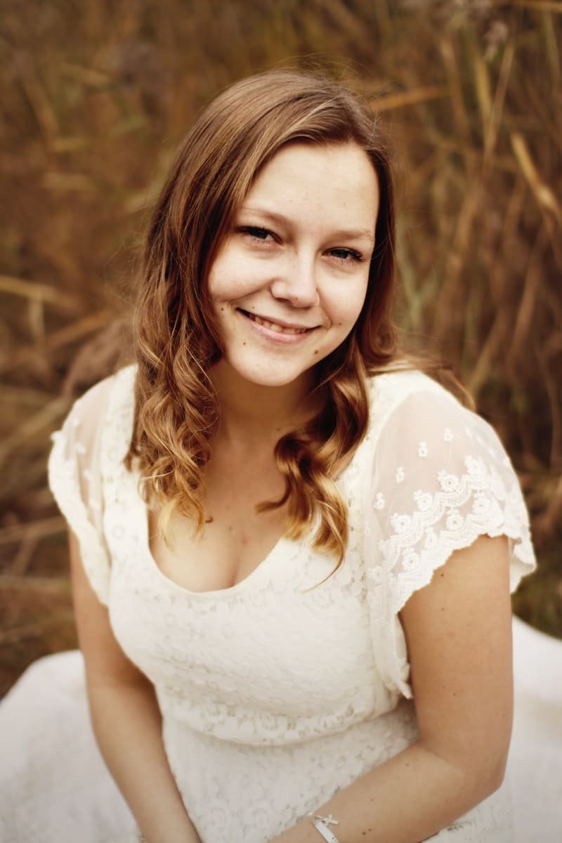 woman sitting near grass field